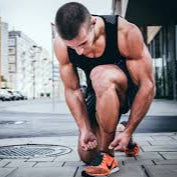 Athlete tying shoes on a city street